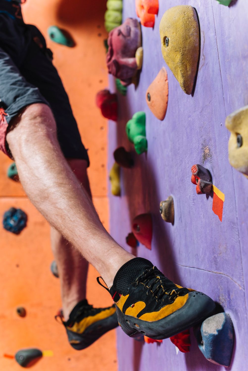 Kletterschuh auf einem bunten Griff an der Boulderwand